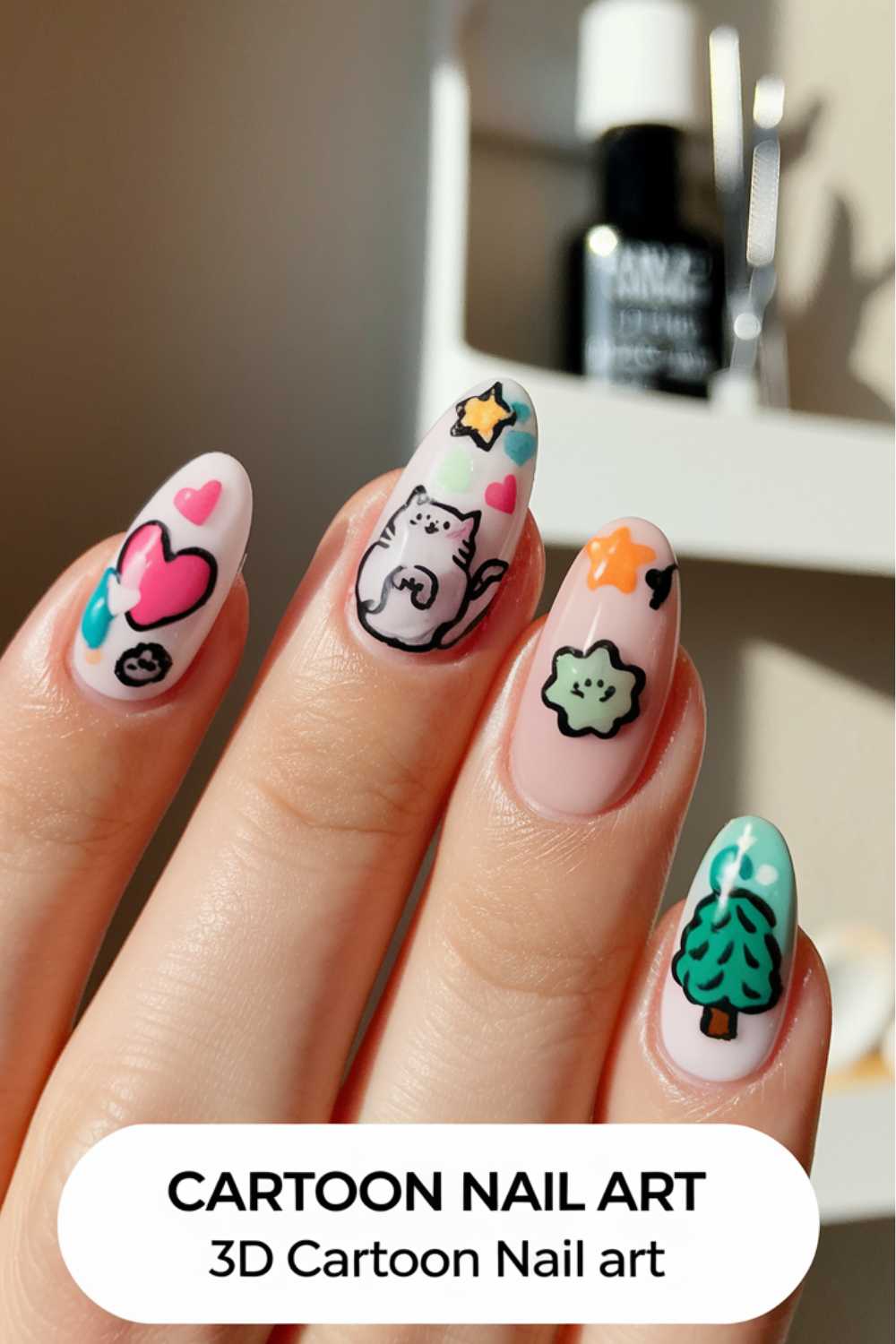 A hand showcases cartoon nail art designs with hearts, a cat, stars, and a tree. The nails boast a light pink base adorned with vibrant creations. Text at the bottom reads CARTOON NAIL ART 3D Cartoon Nail art.