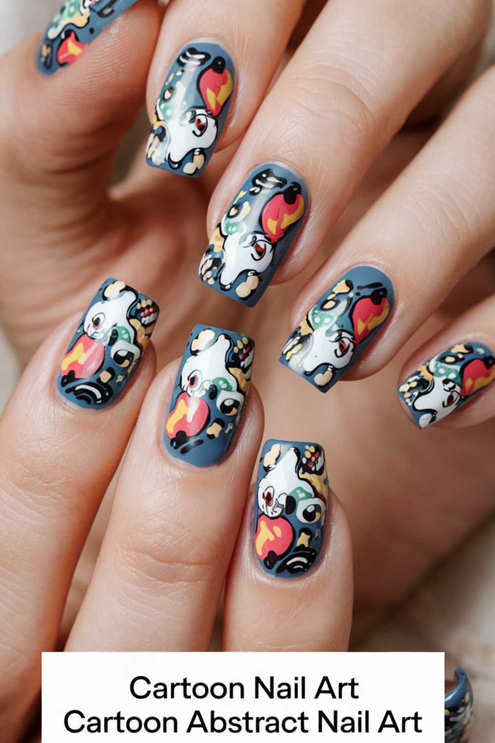 Close-up of hands displaying vibrant cartoon nail art designs on a dark background. Each nail showcases unique artistic patterns, blending playful elements and intricate details.