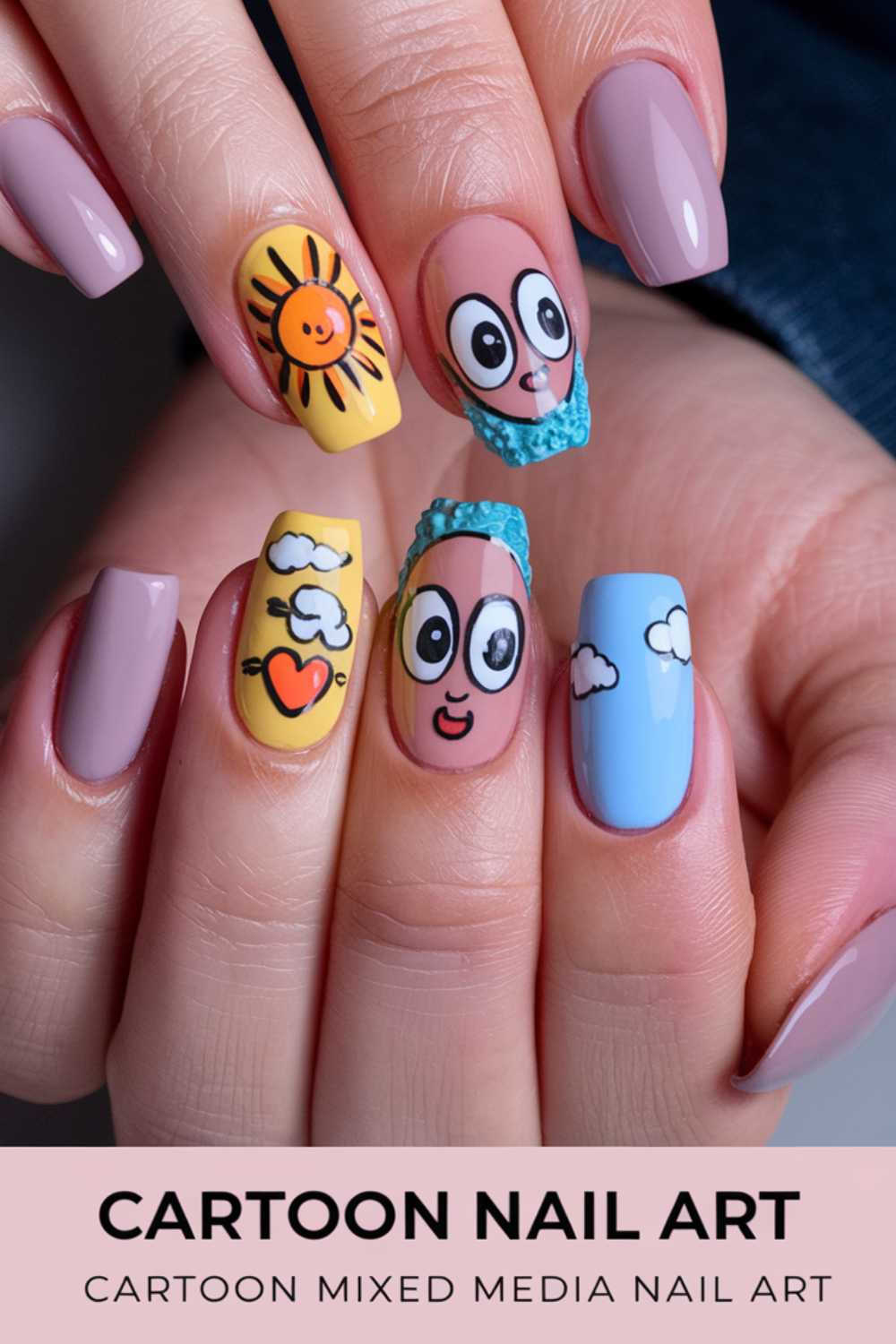 Close-up of a hand with cartoon-themed nail art designs. The nails feature a sun, smiling face, clouds, and a heart with wings. Vibrant colors like blue, yellow, and pink mix with neutral tones. Text reads: CARTOON NAIL ART - CARTOON MIXED MEDIA NAIL ART.